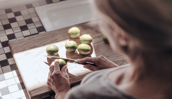 Woman chopping limes on a cutting board